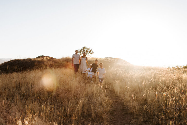 the sun sets behind a family walking through the Wycliffe Buttes