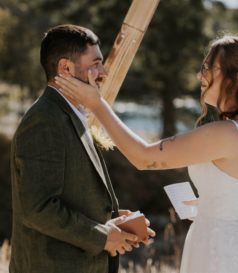 bride wiping away groom's tear at their wedding ceremony on mayne island, british columbia