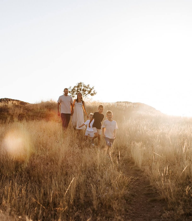 the sun sets behind a family walking through the Wycliffe Buttes