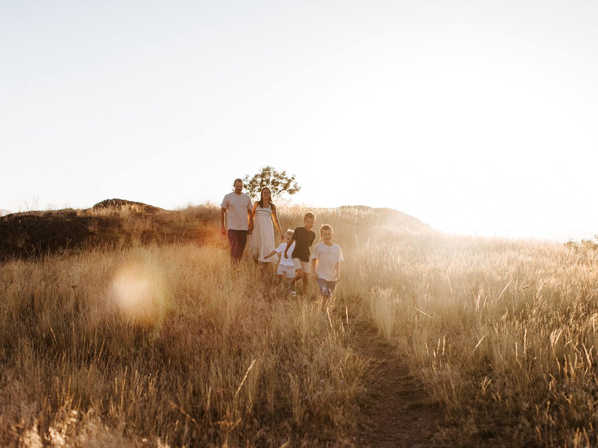 the sun sets behind a family walking through the Wycliffe Buttes