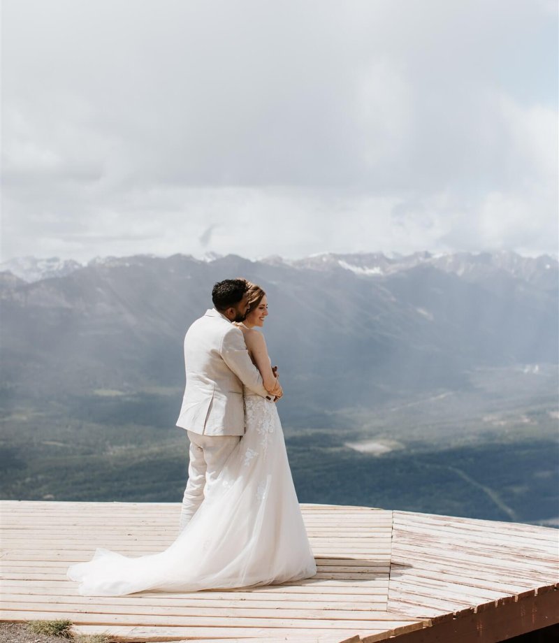 Couple embracing during mountain wedding portraits at Mount 7 in Golden, BC with sweeping mountain views